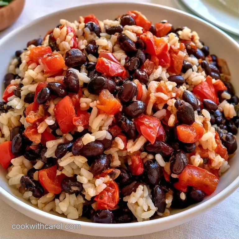 A colorful scoop of seasoned rice and beans topped with sliced avocado and a squeeze of fresh lime on a white plate.