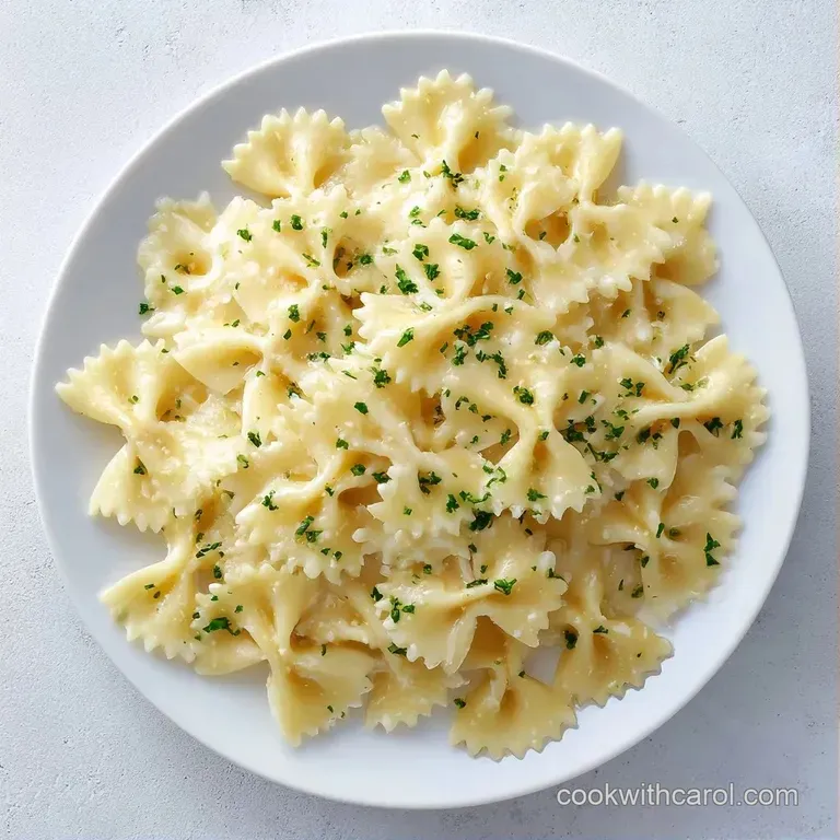 A chilled ceramic platter of pasta tossed in a glossy white sauce with fresh parsley and cracked black pepper.